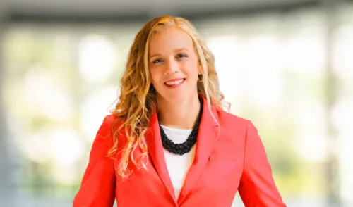 Headshot of Rebecca Woods in red suit