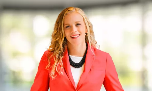 Headshot of Rebecca Woods in red suit